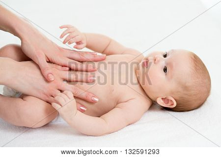 Baby massage. Mom massaging kid belly. Treatment of colic