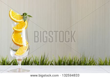 Stack of orange slices juice in a glass concept on blur green background.