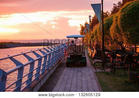 Golf cart at the beach. sunset on the lake
