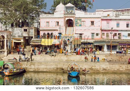MADHYA PRADESH, INDIA - DEC 28, 2015: Old indian city buildings over the river with crowd of people outside on December 28, 2015 in Chitracoot. Population of Chitrakoot is 22294 people.