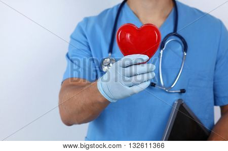 A male doctor holding a heart in hands
