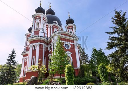 Orthodox Curchi monastery in Moldova with green trees and blue sky