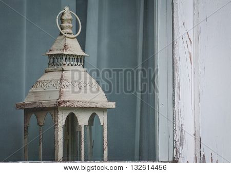 vintage lantern in the frayed window. Ancient suggestion