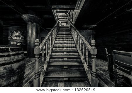 Wooden staircase. Interior of old pirate ship. Black and white image