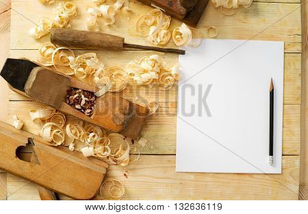 White sheet on wooden table for carpenter tools with sawdust. Copy space. Top view.