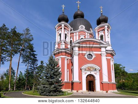 Orthodox Curchi monastery in Moldova with green trees and blue sky