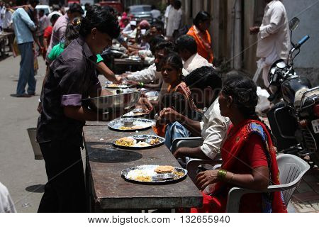 Pune India - July 11 2015: Indian pilgrims known as warkaris been served free meal on the side of the road during Wari festival in India.