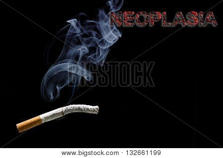 Burned cigarette and text neoplasia on black background