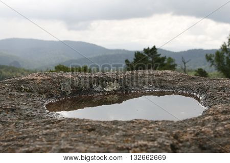 Puddle after the rain in the granite rock.
