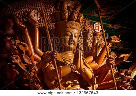 Wooden Guanyin buddha statue with thousand hands in Thailand