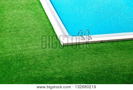 Beautiful swimming pool with green grass around.Lovely pool in the garden in the park.Swimming pool of luxury hotel.Swimming pool with blue clear water.