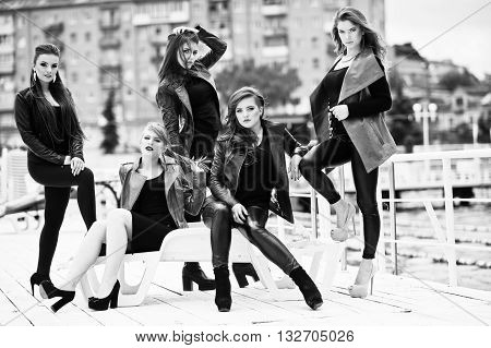 Five Beautiful Young Girls Models At Leather Jackets Posing On Berth. Black And White Photo