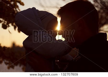 Happy dad with baby silhouette at sunset