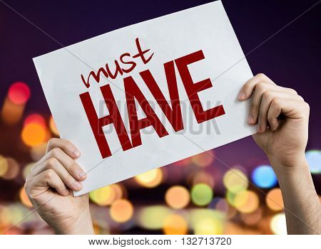 Must Have placard with night lights on background