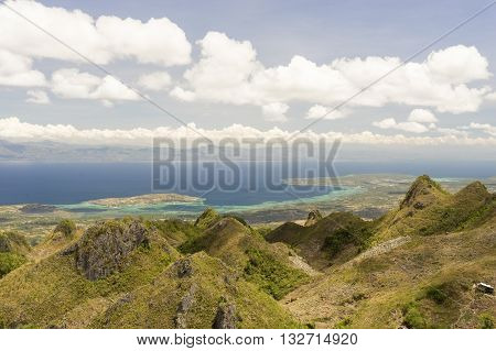 View from mountains to the tropical sea between philippine island under cloudy blue sky