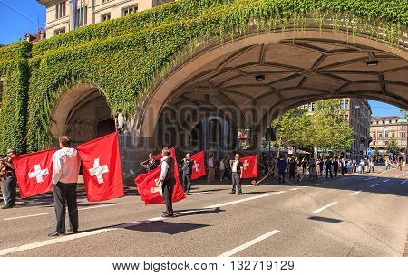 Zurich, Switzerland - 1 August, 2013: participants of the parade devoted to the Swiss National Day on Uraniastrasse street. The Swiss National Day is the national holiday of Switzerland celebrated on the 1st August.