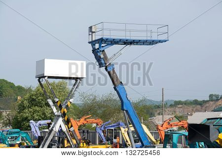 Two platforms high up among the construction equipment.