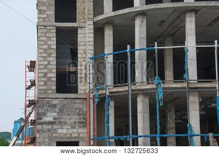Unfinished city building. Scaffolding at construction site