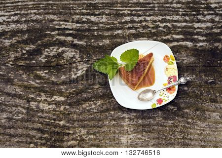 Flan - delicious creme dessert with caramel sauce.French creme caramel dessert or flan with strawberry and mint on the wooden background