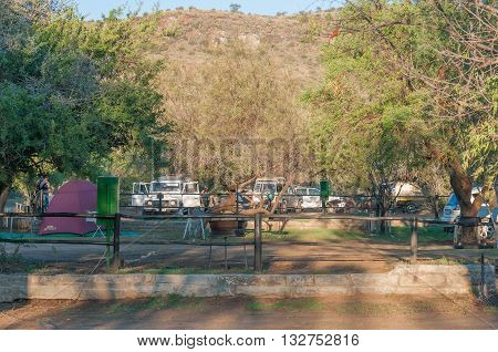 MOUNTAIN ZEBRA NATIONAL PARK SOUTH AFRICA - FEBRUARY 18 2016: Tents vehicles and people at the camping grounds in the Mountain Zebra National Park near Cradock at sunset