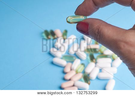 Medicine pills or capsules in hand palm or fingers. Many pills and tablets. Pharmaceutical medicament cure in container for health. Antibiotic painkiller closeup.