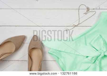 Women clothing set and accessories on a rustic wooden background.Top view Copy space for text.