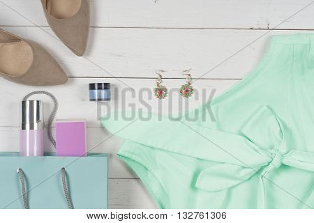 Women clothing set and accessories on a rustic wooden background.Top view Copy space for text.