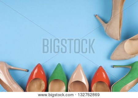 A picture of different shoes Shot of several types of shoes Several designs of women shoes. Leather Shoe. Pile of various female shoes on on light blue background. Copy space for text.