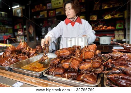 WUZHEN CHINA - MARCH 24: Unidentified Chinese people trade traditional food on March 24 2016 in Wuzhen China. Wuzhen is a historic scenic town located in northern Zhejiang Province China