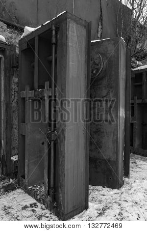 Nuclear bunker. Nuclear bomb shelter. Old abandoned Soviet Cold War bunker in forest. Upcoming reinforced steel hopper gates. Black and white photo.
