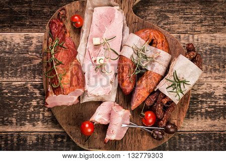 Antipasto catering platter with salami and meat on a wooden background