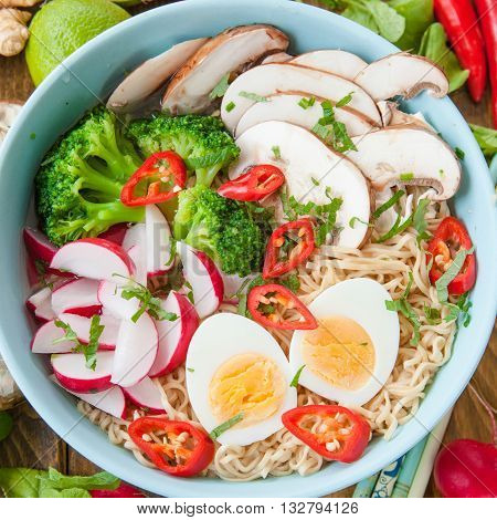 Asian ramen noodle soup with fresh veggies and hardboiled egg