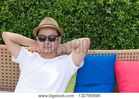 Smart and handsome asian man relexing on vintage sofa copy space.