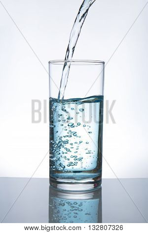 Concept of drinking. Pouring water from into glass