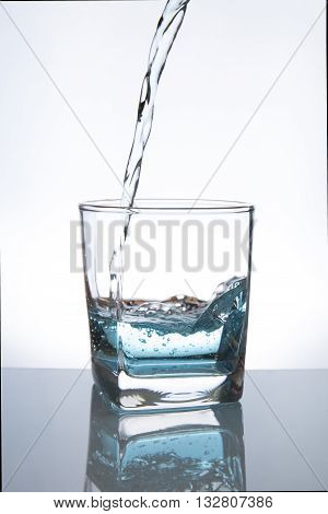 Concept of drinking. Pouring water from into glass