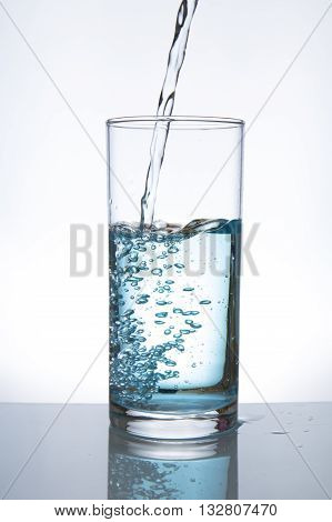 Concept of drinking. Pouring water from into glass