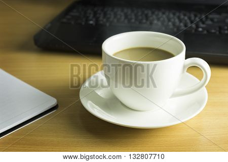 Concept of coffee break. cup of coffee on wooden desk