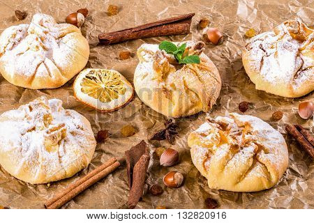 Сoconut puff pastries on parchment paper sprinkled with sugar icing close up