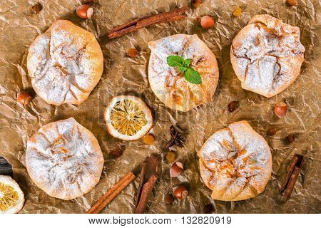 Сoconut puff pastries on parchment paper sprinkled with sugar icing view from above