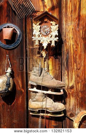 antique old style retro object assemblage on a wooden wall. rustic stile. Clock, bell, old skates and others