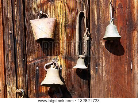 antique old style retro object assemblage on a wooden wall. rustic stile. Old shepherd's bells