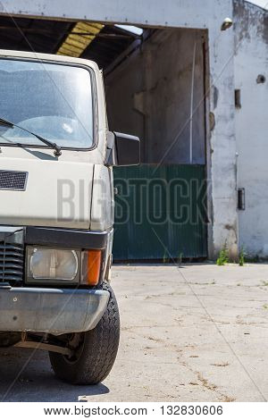 a abadoned work car near deserted storage
