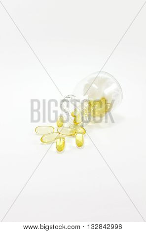 Fish oil capsules in glass jar on white background