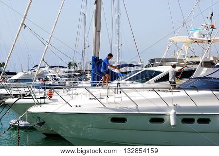 PUERTO SOTOGRANDE, SPAIN - JULY 18, 2008 - Men cleaning a yacht in the marina Puerto Sotogrande Cadiz Province Andalucia Spain Western Europe, July 18, 2008.