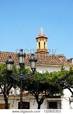 Lamppost with church spire to the rear in the Plaza las Flores Estepona Malaga Province Andalucia Spain Western Europe.