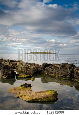 Pladda lighthouse with rocky coastline reflections Isle of Arran Scotland