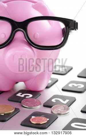 piggy bank on the top of the calculator with coins