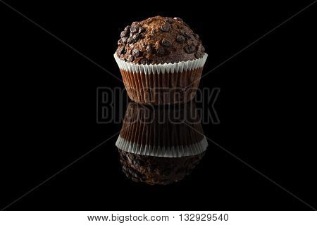 one chocolate muffin on black with reflection