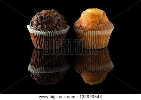 chocolate and orange muffins with reflection on black