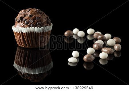 one chocolate muffin on black with reflection